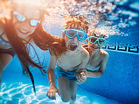 Kinder im Schwimmbad beim tauchen mit Taucherbrille haben Spaß.